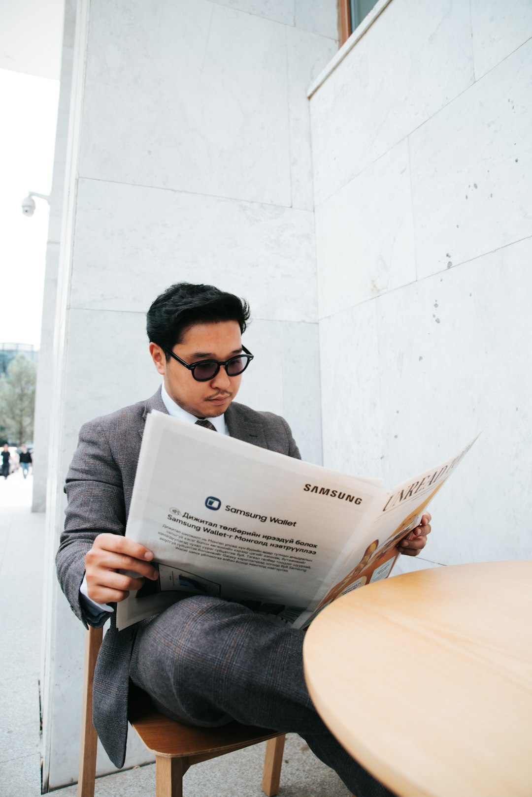 person reading newspaper at cafe